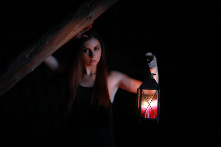 beautiful girl with red hair with a lanternの写真素材