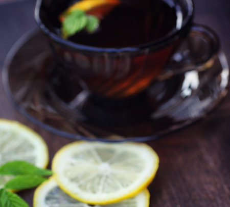 Tea with lemon and mint in nature. A cup of hot mint tea with leの写真素材