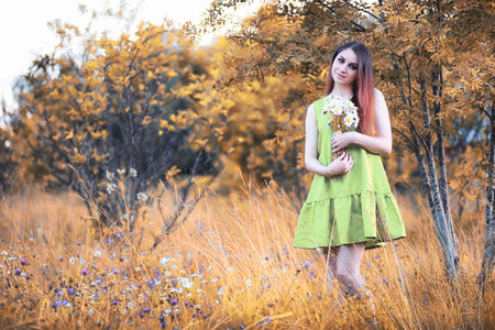 beautiful girl with a bouquet in autumnの写真素材