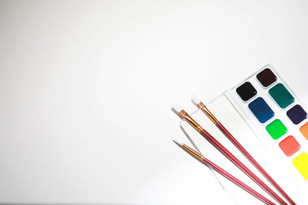 Stationery for drawing paints on a white sheet of paperの写真素材