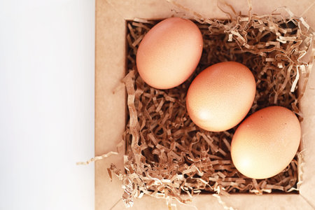 Chicken brown eggs on a white table in a small basket
