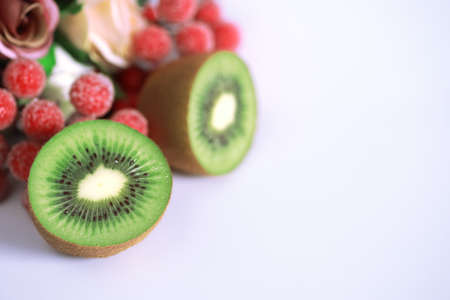 A kiwi fruit is sliced into pieces on a white backgroundの写真素材