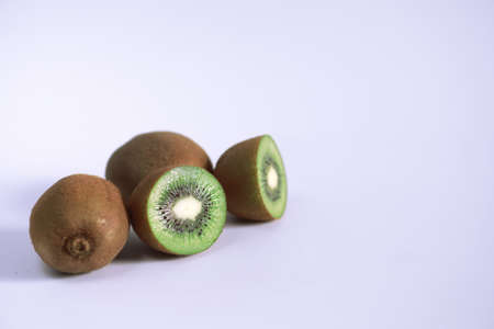 A kiwi fruit is sliced into pieces on a white backgroundの写真素材
