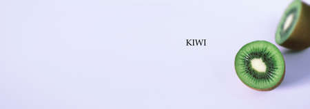 A kiwi fruit is sliced into pieces on a white backgroundの写真素材