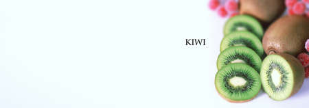 A kiwi fruit is sliced into pieces on a white backgroundの写真素材