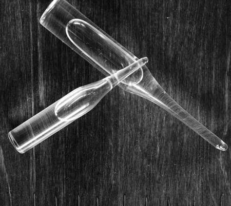 Ampoule and needles from a medical syringe on wooden backgroundの写真素材