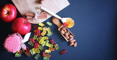 Marmalade in a vase on table. Sweets in a bowl on a black background. Multicolored jelly sweets for children.の写真素材