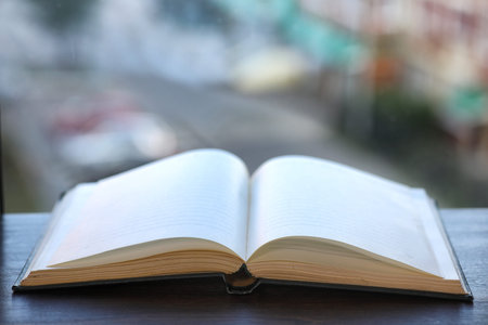 open book and a table in front of the windowの写真素材