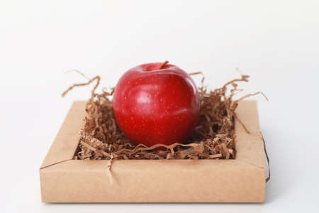 Fresh juicy apples on a white table in a small basketの写真素材