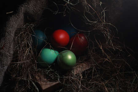 Easter painted eggs on burlap and strawの写真素材