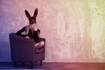 A girl in a black mask with long ears in the studioの写真素材