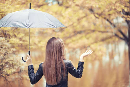 Young girl in autumn in rainy weatherの写真素材