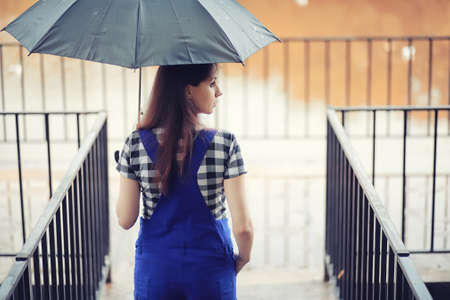 Young girl in autumn in rainy weatherの写真素材