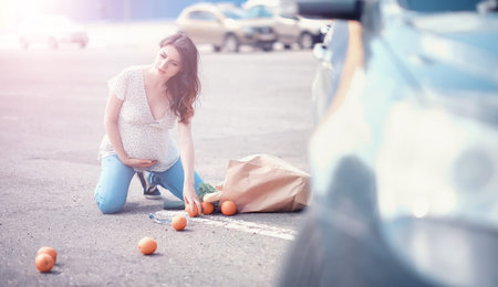 Pregnant girl drops shopping on the way out of the storeの写真素材