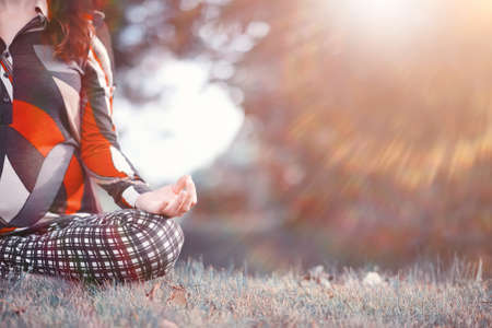 Pregnant woman doing yoga exercise in nature on a autumn dayの写真素材