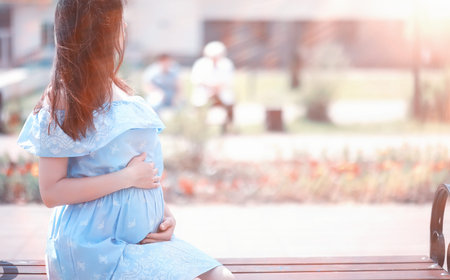 Pregnant girl in a dress in nature on a walk