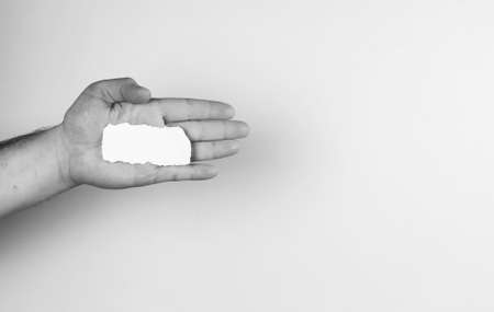 a small white piece of paper in his hand manの写真素材