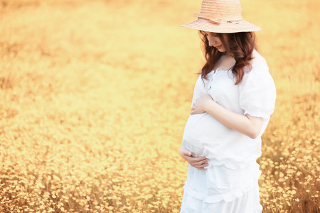 Pregnant woman in nature for a walk in the autumn