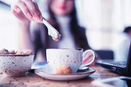 Girl eating coffee cakes and drinking coffeeの写真素材