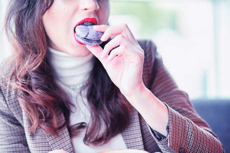 Girl eating coffee cakes and drinking coffeeの写真素材