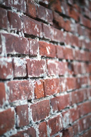 Old red brick wall with a crack and traces of paintの写真素材