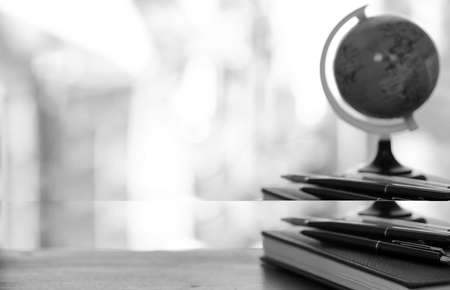 A pen on the desk and a small blue globeの写真素材