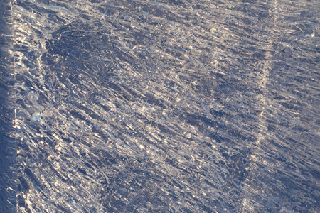 Texture of ice in winter. Pieces of frozen water on a street in the winter. The texture and texture...