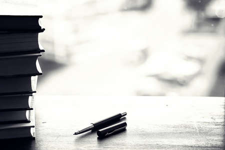 A stack of textbooks on the windowsill and writing utensilsの写真素材