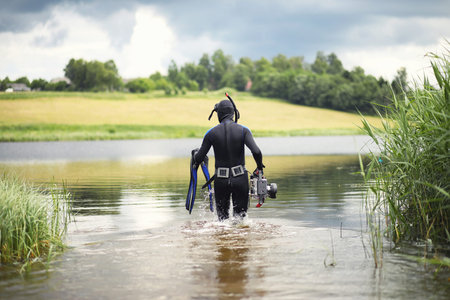 A scuba diver in a wet suit prepares