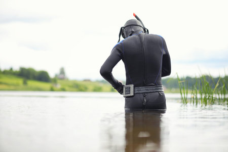 A scuba diver in a wet suit prepares