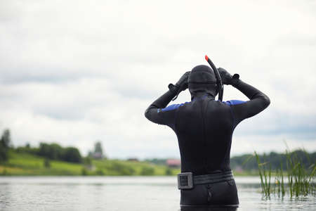 A scuba diver in a wet suit preparesの写真素材