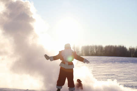 Santa in the winter field. Santa magical fog is walking along a snowy roadの写真素材