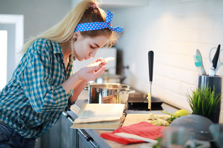A cute young girl in the kitchen preparing food