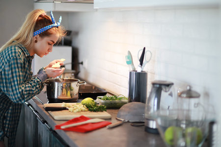 A cute young girl in the kitchen preparing food