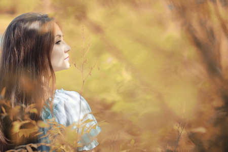 Young girl on a walk in the park in autumnの写真素材