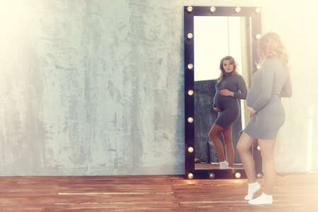 Pregnant young and beautiful girl in a vintage homeの写真素材