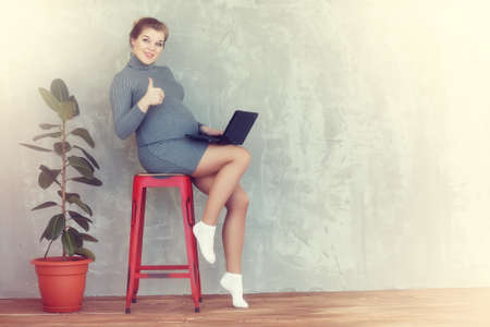 Pregnant young and beautiful woman at home in a vintage tonedの写真素材