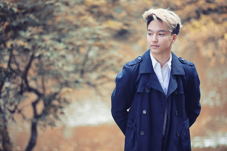 Autumn rainy weather and a young man with an umbrella