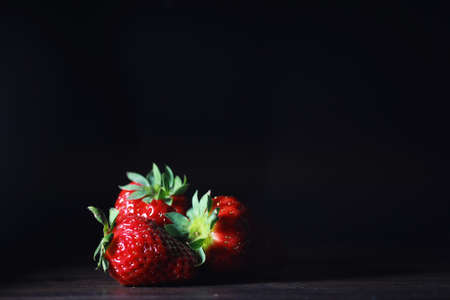 Fresh ripe strawberries on a wooden table and ice cubes with waterの写真素材