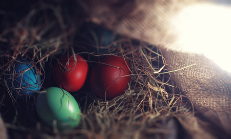 Easter painted eggs on burlap and strawの写真素材