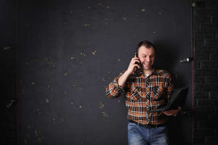 Male architect builder in a protective helmet talking to a phoneの写真素材