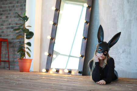 A girl in a black mask with long ears in the studioの写真素材