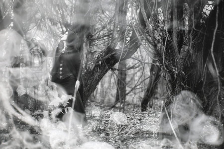 Woman in a witch suit in a dense forest