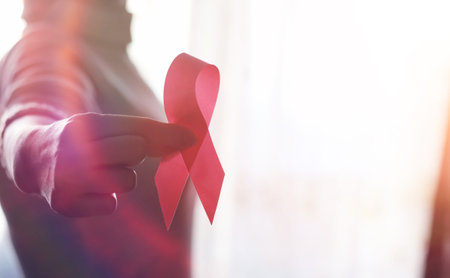 The red ribbon of the girl. The girl is holding a red ribbon. Health concept red ribbon. Breast...