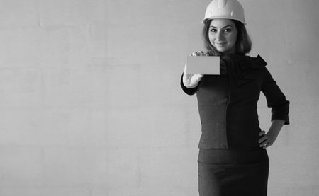 A girl with a blank sheet of paper in her hand on construction site