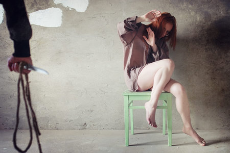 A girl with red hair in a shirt. Domestic violence and sacrifice. Girl with a sick psyche.