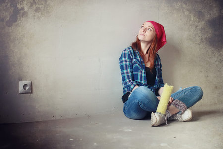 A girl  doing repairs in the apartment. Home moving to a new apartment.