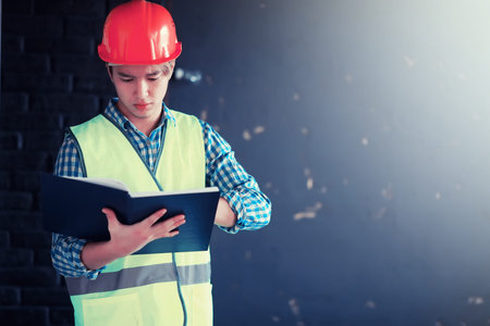 Asian man in protective helmet and construction waistcoat