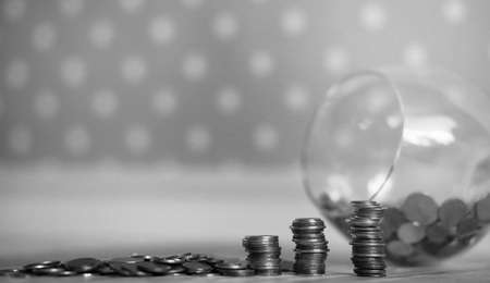 Coins in a jar on the floor. Accumulated coins on the floor. Pocket savings in piles.の写真素材