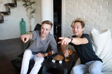 Football fans watch the match and drink beerの写真素材